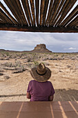 USA, New Mexico, Chaco Canyon National Historic Park, Rear view of woman in straw hat looking at Fajada Butte in Chaco Canyon in Chaco Culture National Historical Park