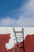 USA, New Mexico, Madrid, Leiter vor teilweise braun-weiß gestrichener Wand