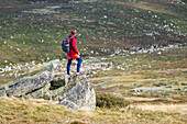 Australien, Neusüdwales, Mann steht auf einem Felsen am Charlotte Pass im Kosciuszko-Nationalpark