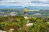Australien, New South Wales, Bald Rock National Park, Mann steht auf einem Felsen und sieht sich um
