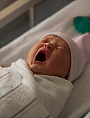 Yawning newborn baby girl (0-1 months)