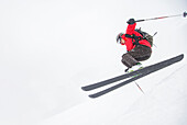 Skifahrer springt auf verschneiter Piste