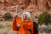 USA, Utah, Escalante, Woman looking at feather while hiking in Grand Staircase-Escalante National Monument