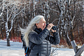 USA, Idaho, Bellevue, Ältere Frau benutzt Fernglas beim Wandern