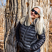 Porträt einer älteren Frau vor einem Pappelbaum