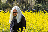 Senior woman in field of wild mustard