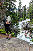 USA, Idaho, Stanley, Senior female hiker looking at waterfall