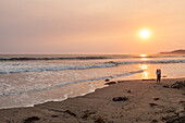USA, California, Cayucos, Mother and daughter (4-5) on beach at sunset