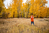 USA, Idaho, Bellevue, Rückansicht einer Frau auf einer Wiese im Herbst