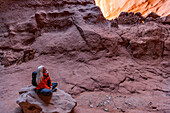 Vereinigte Staaten, Utah, Escalante, Ältere Wanderin sitzt auf einem Felsen im Canyon