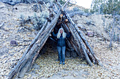United States, Utah, Escalante, Senior female hiker standing in log shelter structure