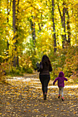 USA, Idaho, Hailey, Mother and daughter (6-7) run through the forest