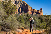 Vereinigte Staaten, Arizona, Sedona, Ältere blonde Frau beim Wandern in der Wildnis