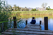 South Africa, Stanford, Boy (8-9) sitting on wooden pier