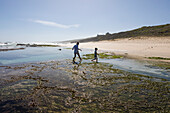 South Africa, Western Cape, Boy (8-9) and girl (16-17) exploring tidal pools in Lekkerwater Nature Reserve
