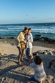 South Africa, Western Cape, Mother with boy (8-9) and girl (16-17) taking pictures on beach