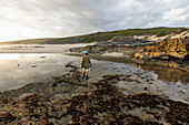 South Africa, Western Cape, Boy (8-9) exploring tidal pools in Lekkerwater Nature Reserve