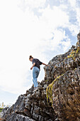 Südafrika, Hermanus, Mädchen (16-17) balanciert auf einem Felsen am Grotto Beach