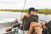 Africa, Zambia, Boy (8-9) in boat on Zambezi River near Tongabezi River Lodge