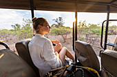 Africa, Namibia, Girl (16-17) in safari vehicle