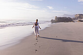 South Africa, Hermanus, Girl (16-17) walking on Sopiesklip beach in Walker Bay Nature Reserve