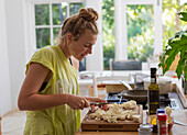 Girl (16-17) preparing meal in kitchen