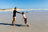South Africa, Hermanus, Girl (16-17) and boy (8-9) playing on Grotto Beach