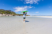 South Africa, Hermanus, Boy (8-9) carrying body board on Grotto Beach
