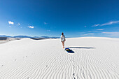 Vereinigte Staaten, New Mexico, White Sands National Park, Jugendliches Mädchen zieht Schlitten in der Wüste