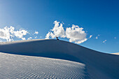 United States, New Mexico, White Sands National Park, Boy (10-11) sand boarding in desert