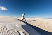 United States, New Mexico, White Sands National Park, Teenage girl leaping on sand dunes