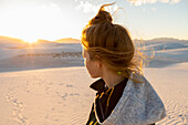 Vereinigte Staaten, New Mexico, White Sands National Park, Mädchen im Teenageralter betrachtet den Sonnenuntergang