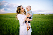 Mother with baby son (12-17 months) in agricultural field