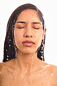 Studioaufnahme einer Frau mit Wasser im Gesicht