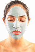 Studioaufnahme einer Frau mit blauer Gesichtsmaske