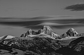 Black and white of Grand Teton, Middle Teton and Mount Owen with cirrus cloud seen from the west.