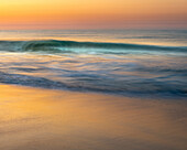 USA, New Jersey, Cape May National Seashore. Wave on beach at sunrise.