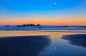 USA, Oregon, Bandon. Monduntergang am Strand bei Sonnenaufgang