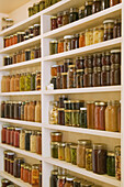 Pantry of preserved fruits and vegetables in canning jars. (PR)