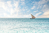 Traditionelle afrikanische Dhau segelt in den ruhigen Gewässern des Indischen Ozeans, Sansibar, Tansania, Ostafrika, Afrika