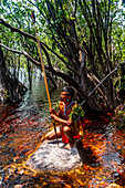 Man from the Yanomami tribe with bow and arrow in the swamplands, southern Venezuela, South America