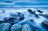Felsen und Summer Isles im Hintergrund bei dramatischer blauer Beleuchtung in der Abenddämmerung an der Küste von Nordwest-Schottland, Highland, Schottland, Vereinigtes Königreich, Europa