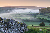 Kilnsey Crag and low lying mist at daybreak in Wharfedale, The Yorkshire Dales, Yorkshire, England, United Kingdom, Europe