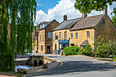 Dorfszene mit Brücke über den Fluss Windrush, Bourton-on-the-Water, Cotswolds, Gloucestershire, England, Vereinigtes Königreich, Europa