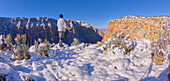 A hiker standing on a snowy cliff on the east rim of Grand Canyon National Park, UNESCO World Heritage Site, Arizona, United States of America, North America