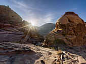 Felsige Berge mit dem Sonnenstern im Wadi Rum, Jordanien, Naher Osten