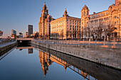 Evening light illuminates the Liver Building, the Cunard Building and Port of Liverpool Building (The Three Graces), Pier Head, Liverpool Waterfront, Liverpool, Merseyside, England, United Kingdom, Europe