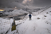 Wanderer auf dem PYG-Weg mit Blick auf Cwm Dyli, Llyn Llydaw und Y Lliwedd im Winter, Snowdonia-Nationalpark, Eryri, Nordwales, Vereinigtes Königreich, Europa