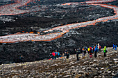 Touristen beobachten fließende Lava am Vulkan Fagradalsfjall, Reykjanes-Halbinsel, Island, Polarregionen