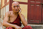 Senior monk resting outside of Shwenandaw Temple, Mandalay, Myanmar (Burma), Asia